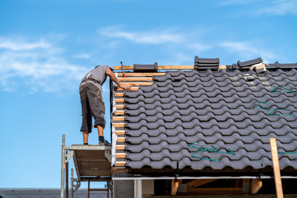 A contractor working on a ceramic tile roofing installation.